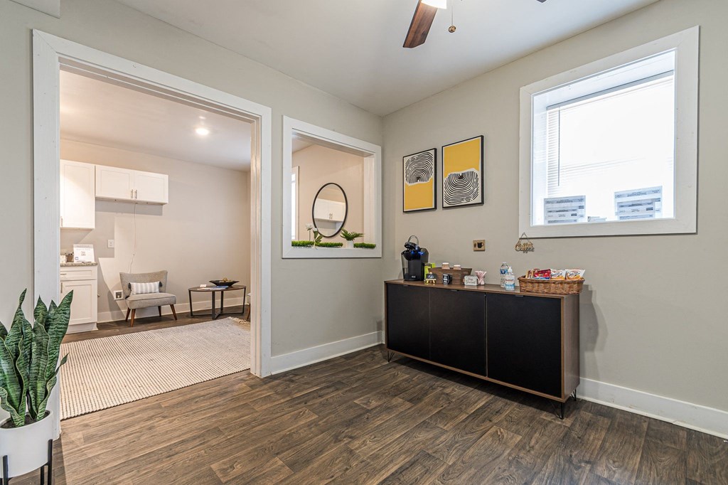 a room with two windows and a dresser with a mirror and other items on it at Georgian Oaks Apartments, Smyrna Georgia