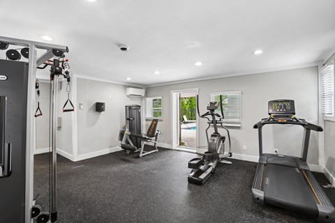 A spacious home gym with a treadmill, elliptical trainer, and other exercise equipment.