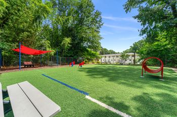 a park with a playground and kids playing in the grass at Georgian Oaks Apartments Apartments, Smyrna