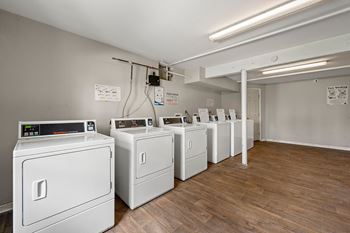 a row of washes and dryers at Georgian Oaks Apartments Apartments, Georgia