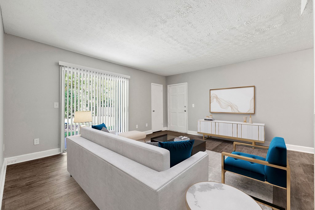 A living room with a couch and chairs and a table at Pines at Lawrenceville Decatur 30033