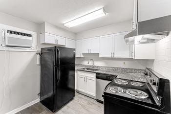 a kitchen with white cabinets and black appliances  at Balfour 296, Lilburn, GA