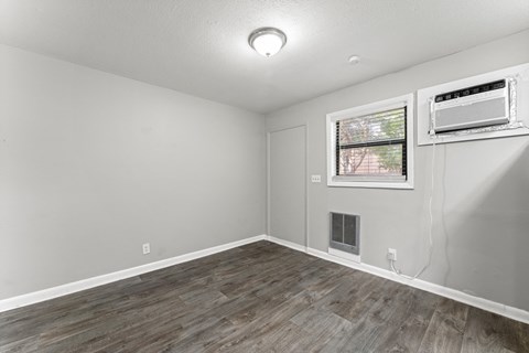 a bedroom with hardwood floors and grey walls