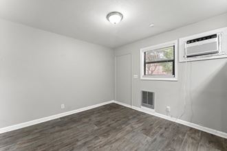 a bedroom with hardwood floors and grey walls