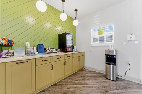 A kitchen with wooden cabinets and a green wall.