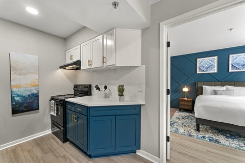 A kitchen with a blue cabinet and a painting on the wall.
