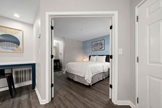 a bedroom with a bed and a desk in a room