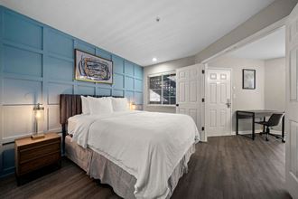 a bedroom with a bed and a desk in front of a window