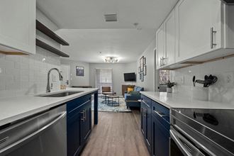 a kitchen with white countertops and blue cabinets