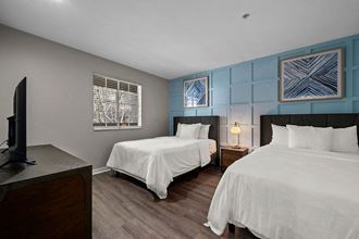 a bedroom with two beds and a tv