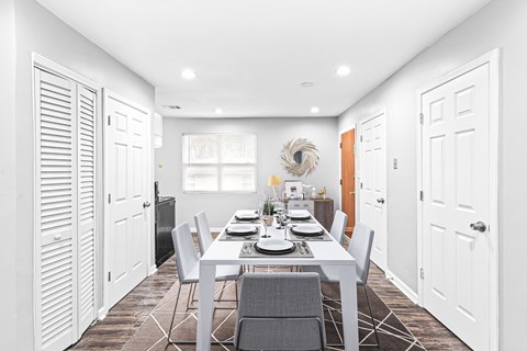 A modern dining room with a white table and chairs.