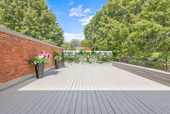 a deck with a brick wall and a wooden floor at Crogman School Lofts in Atlanta, GA