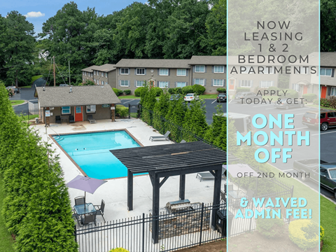 Apartment complex with a pool and a sign offering a free month of rent.
