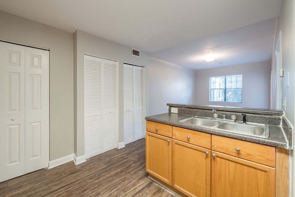 an empty kitchen with a sink and wooden cabinets at Crogman School Lofts, Atlanta, 30315