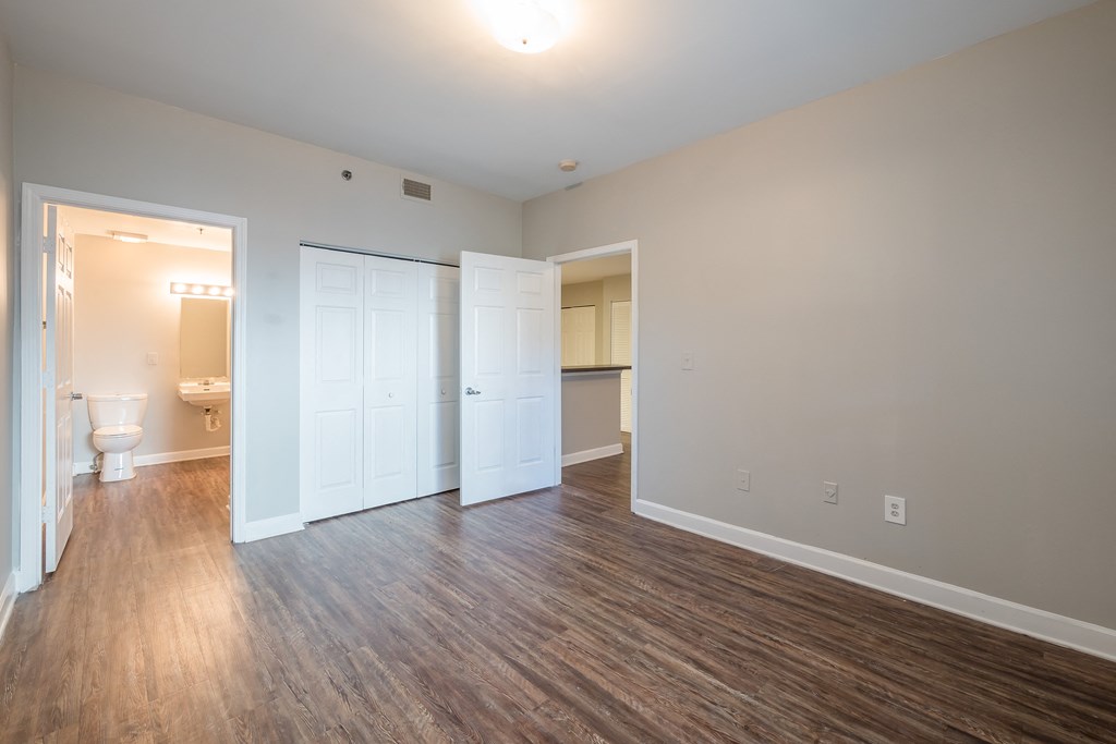 an empty living room with wood flooring and a bathroom at Crogman School Lofts, Georgia