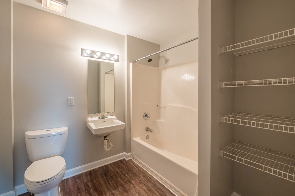 a bathroom with a toilet and a tub and a sink at Crogman School Lofts, Georgia, 30315
