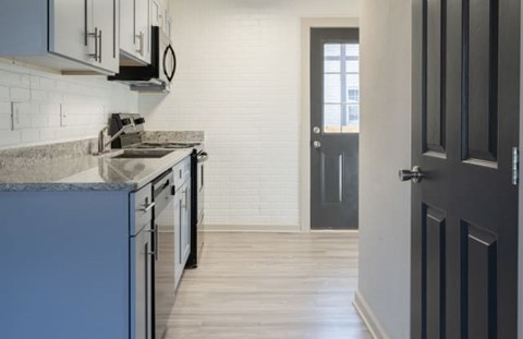 A kitchen with a sink and a door.