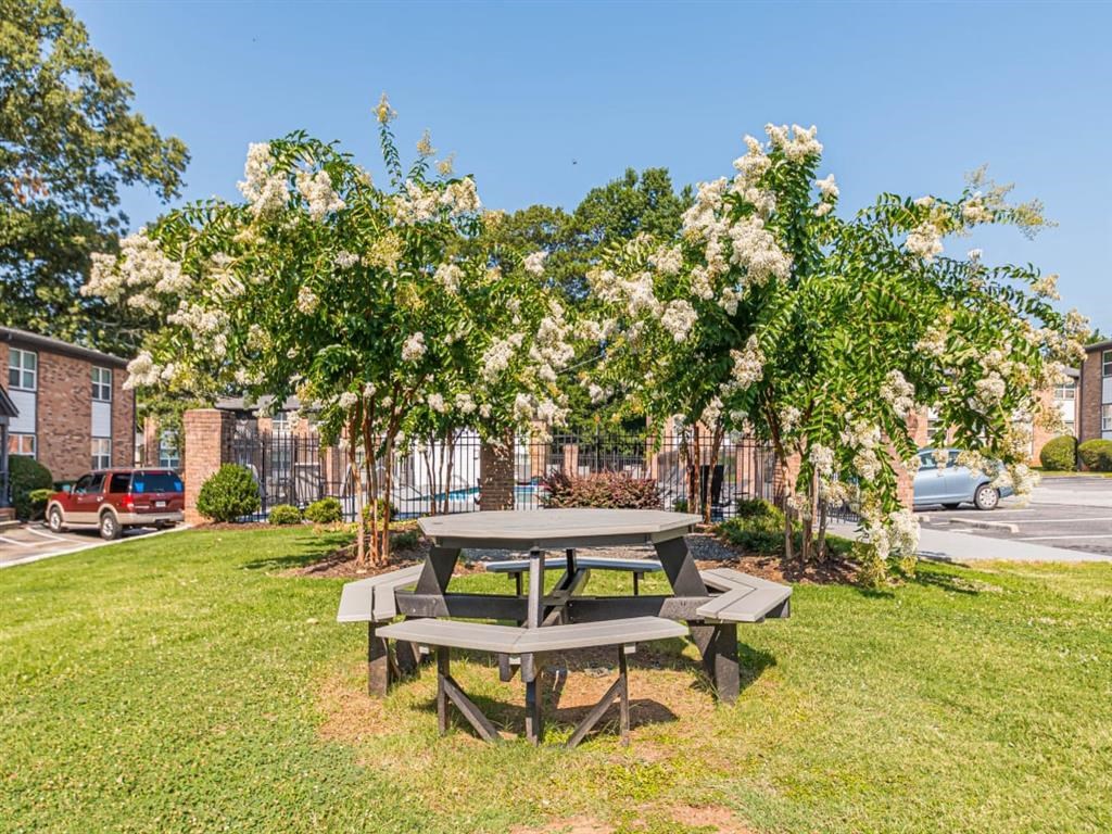 a picnic table in a park next to a parking lot
