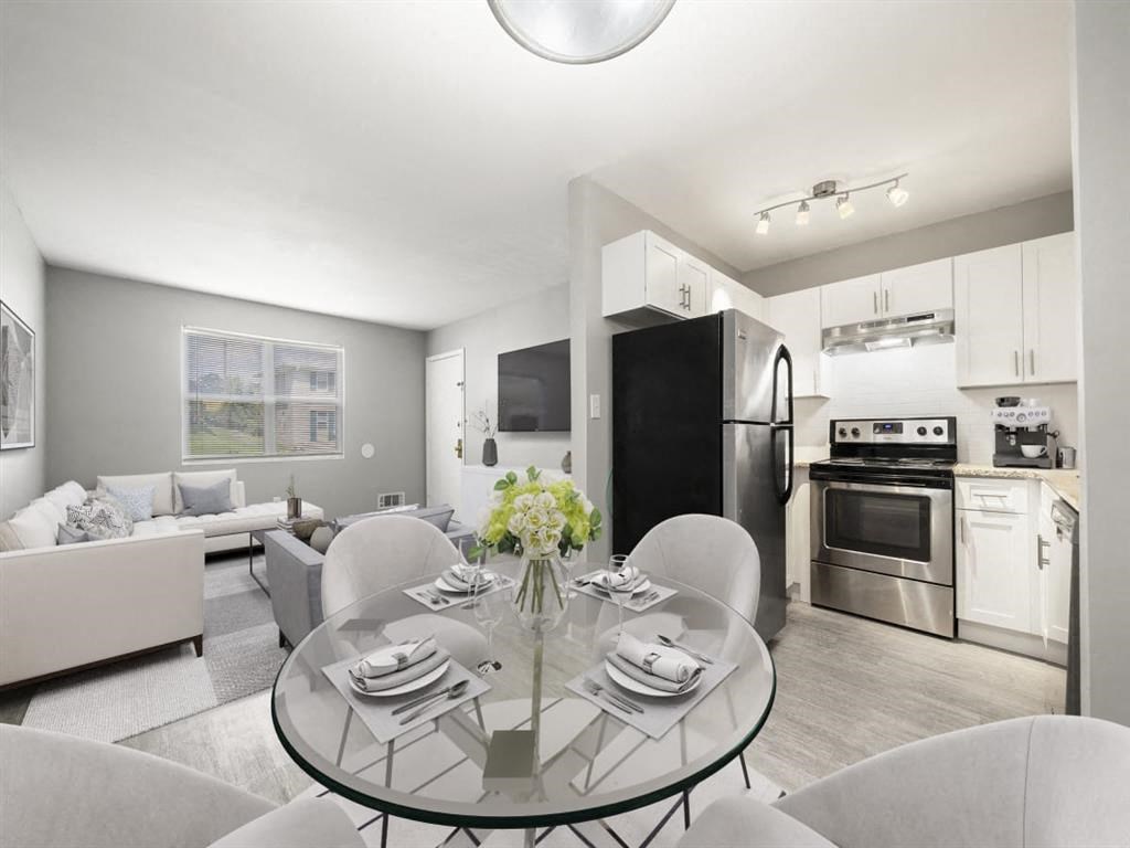 a kitchen and living room with a glass table