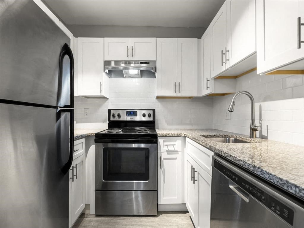 a kitchen with stainless steel appliances and white cabinets