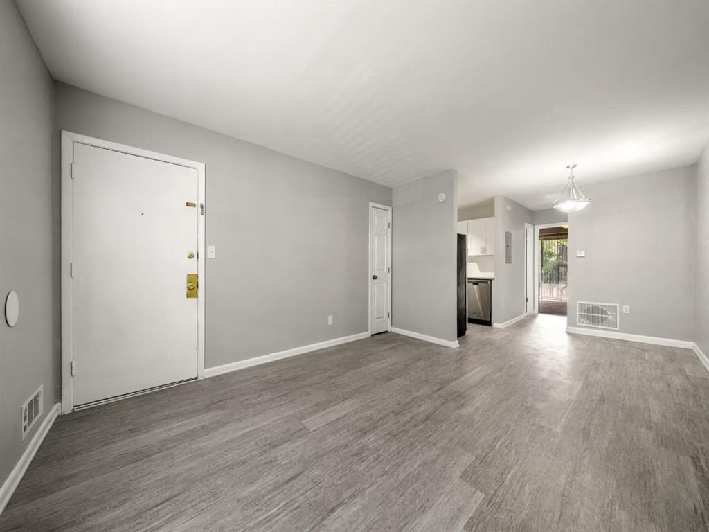 the living room and dining room of a house with a wood floor