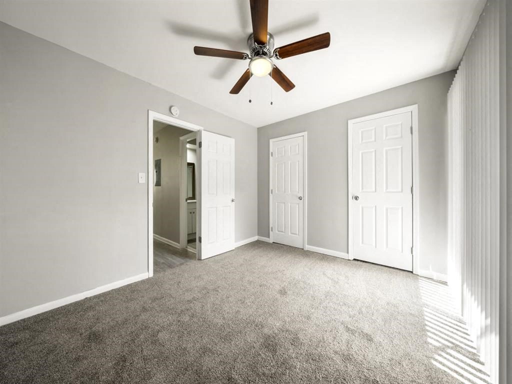 an empty living room with a ceiling fan