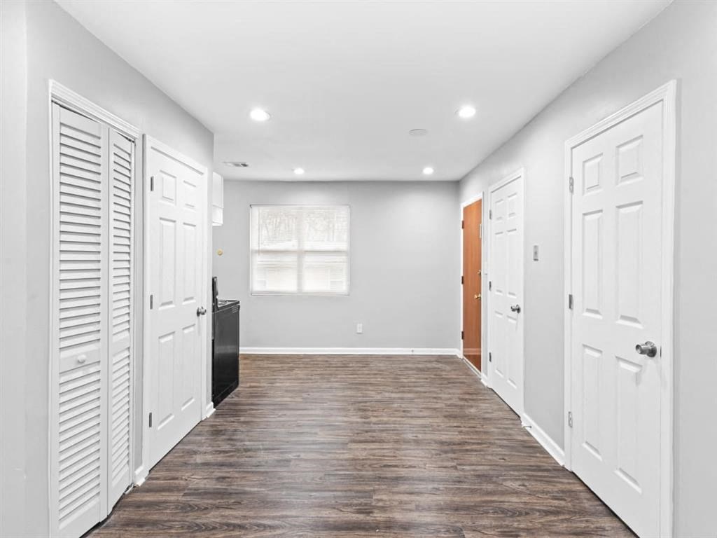 an empty room with white closets and a window