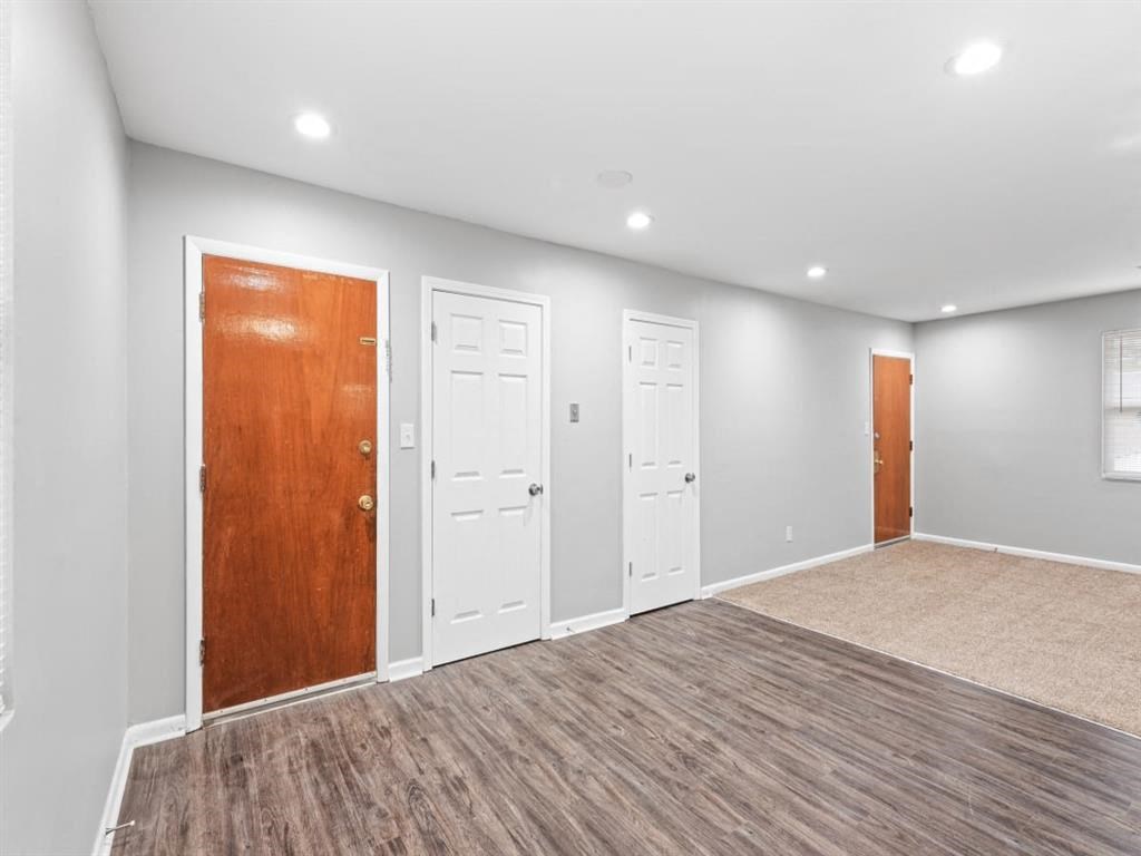a empty room with three doors and a carpeted floor