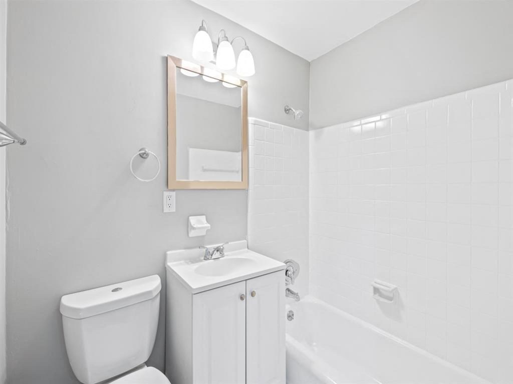 a white bathroom with a toilet and a sink