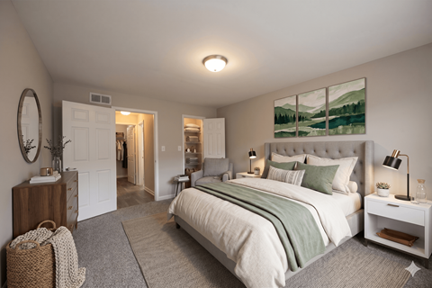 A bedroom with a large bed and a painting on the wall.