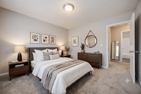 A bedroom with a large bed, nightstands, and a mirror.