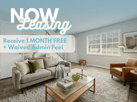 A living room with a couch, chair, and coffee table is advertised for leasing with a free month and waived admin fee.