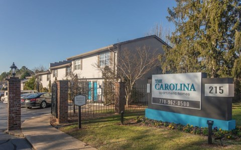 Community entrance with monument sign and brick pillars at The Carolina Apartments, Lawrenceville, GA 30046