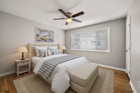 A bedroom with a bed, nightstand, and window.