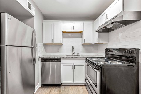 A kitchen with a stainless steel refrigerator and black stove.
