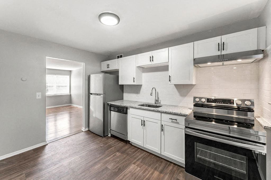 a kitchen with stainless steel appliances and white cabinets a kitchen with stainless steel appliances and white cabinets at Gardens at Washington Park, Atlanta, Georgia