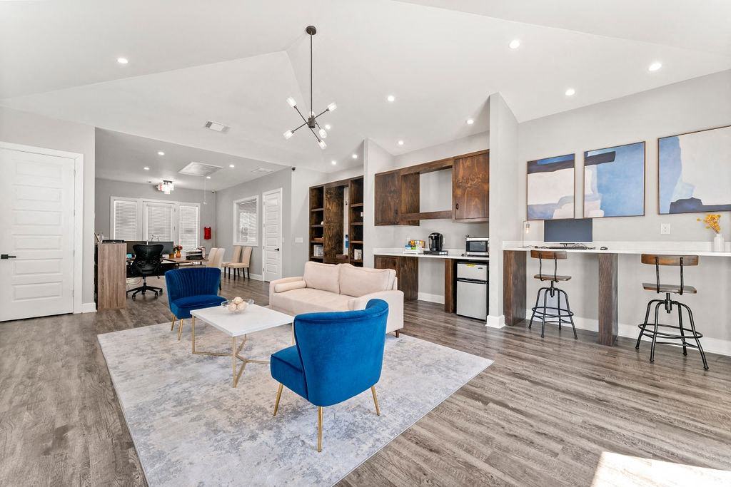A modern living room with a blue chair and a white couch.