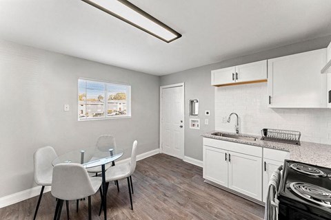 A kitchen with a table and chairs.