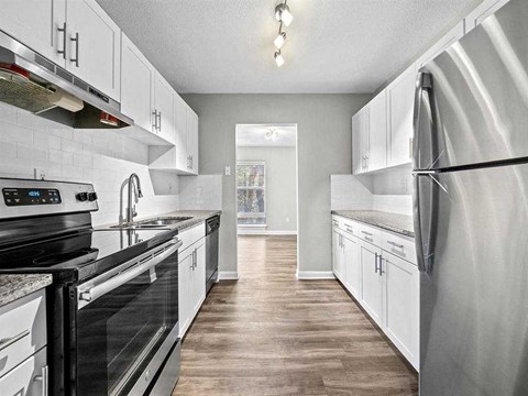 A kitchen with white cabinets and a black stove top oven.
