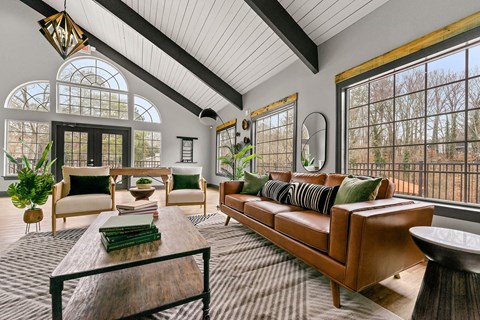 A living room with a brown leather couch and a wooden coffee table.