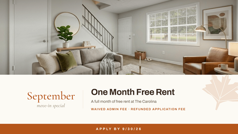 A living room with a couch, chair, and a plant on a table with a sign offering a free rent for September.