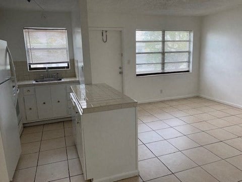 an empty kitchen with a sink and a refrigerator
