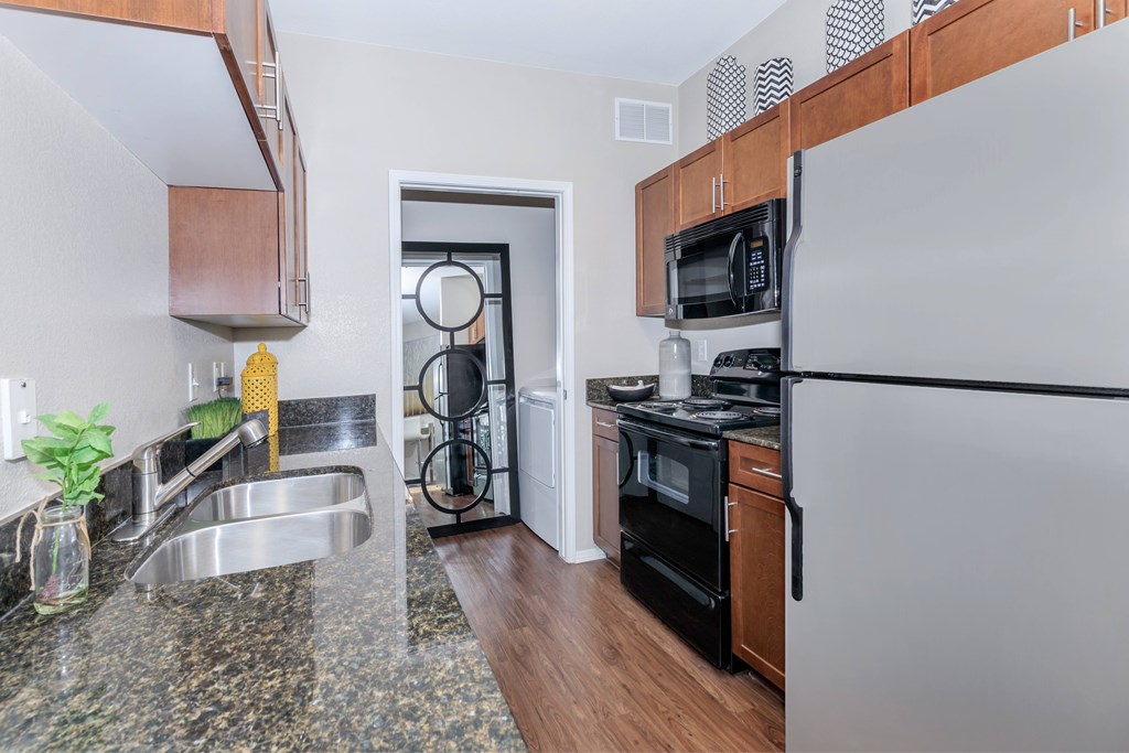 A kitchen with black appliances and a white refrigerator.
