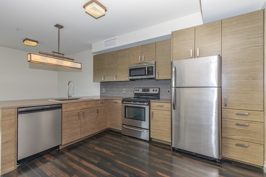 A modern kitchen with stainless steel appliances and wooden cabinets.