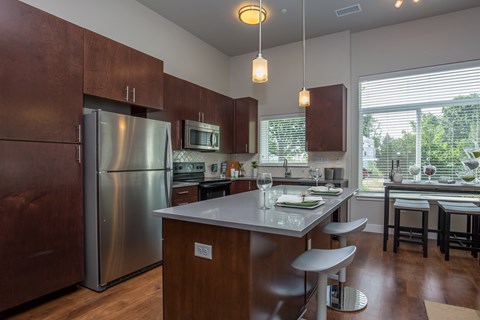 A kitchen with a refrigerator, microwave, and oven.