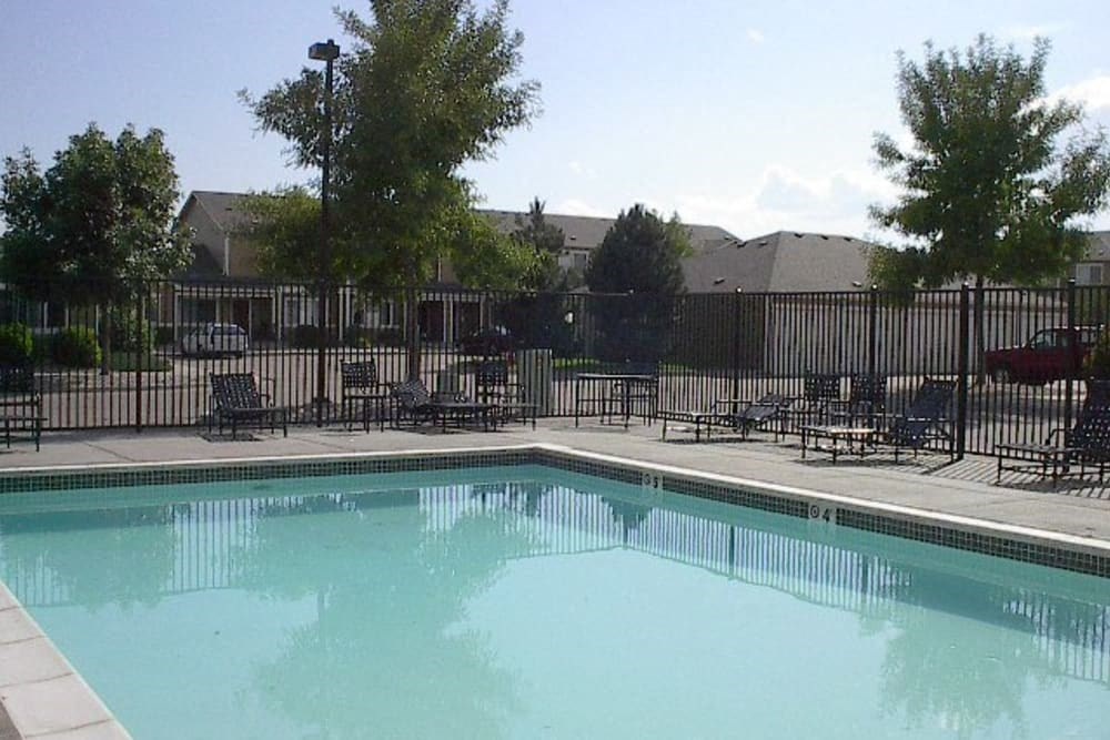 a swimming pool with chairs and a fence