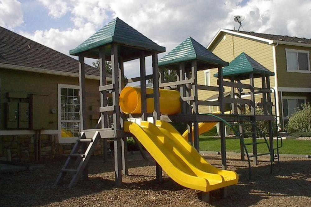 a playground with a yellow slide and