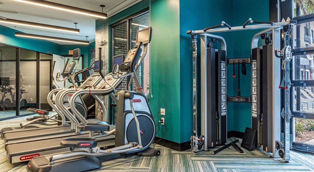 a gym with cardio machines and weights in a building