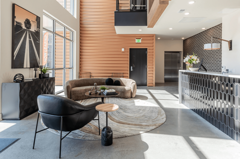 A modern living room with a black chair and a wooden coffee table.