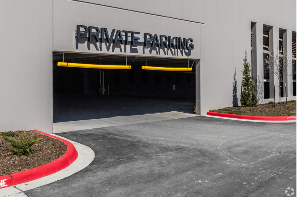A private parking garage entrance with a red curb.